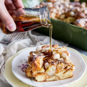 Maple syrup is being pour over a piece of almond croissant french toast bake
