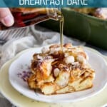 Maple syrup is being pour over a square of almond croissant french toast on a plate.