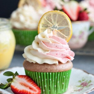 Strawberry lemonade cupcake decorated with a candied lemon slice on a plate