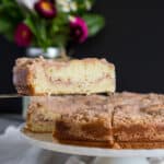 A slice of buttermilk coffee cake is lifted from the cake stand.