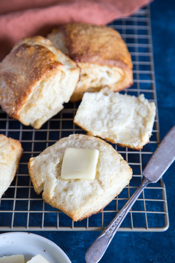 Honey buttermilk biscuit cut open with a pat of butter on top