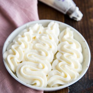 Cream cheese frosting piped on a plate.