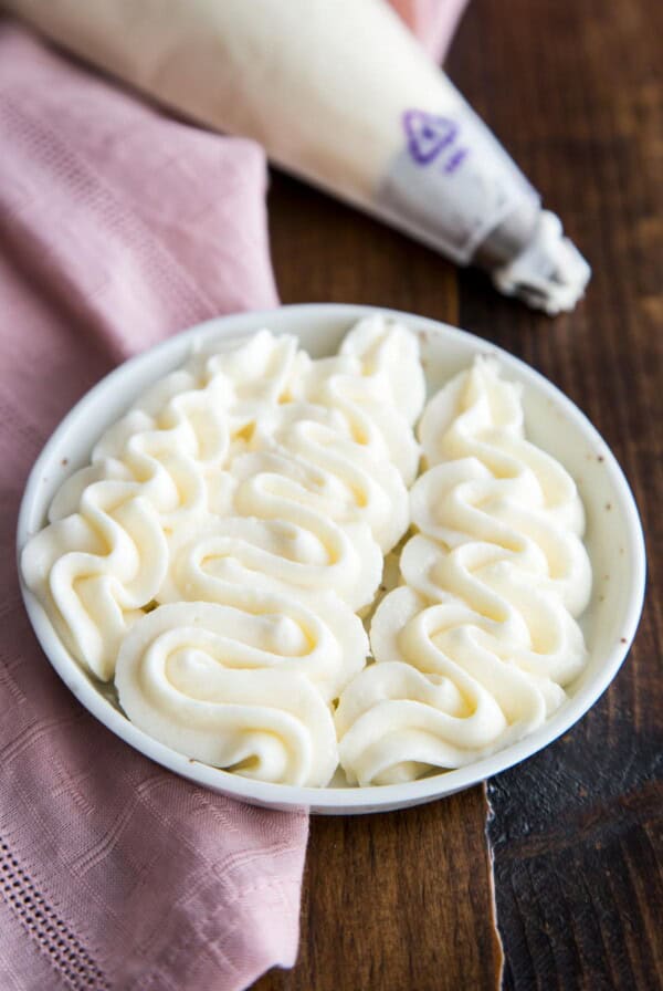 Cream cheese frosting piped on a plate.