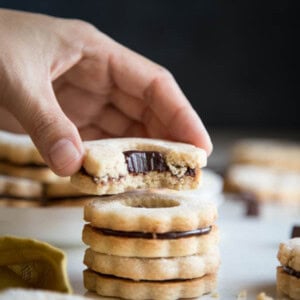 A stack of chocolate ganache linzer cookies