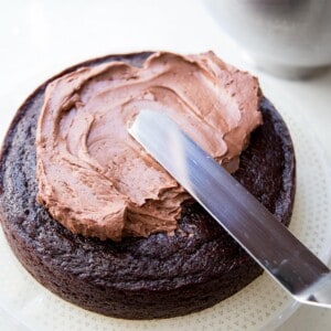 Adding chocolate buttercream on chocolate cake.