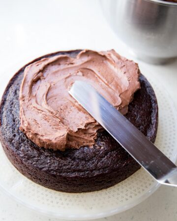 Adding chocolate buttercream on chocolate cake.
