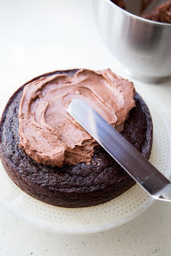 Adding chocolate buttercream on chocolate cake.