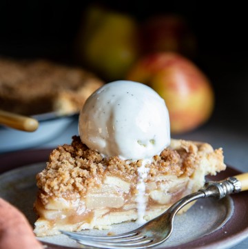 A slice of apple pear pie with a scoop of ice cream on top