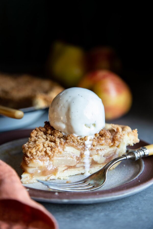 A slice of apple pear pie with a scoop of ice cream on top
