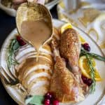Gravy is being drizzled over a platter of turkey