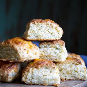 A stack of cheese biscuits on a wooden board.