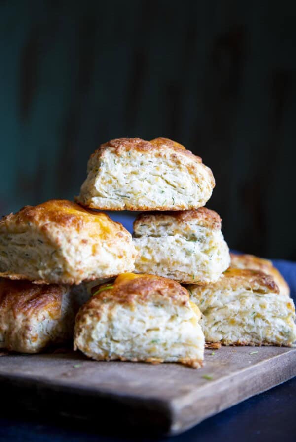 A stack of cheese biscuits on a wooden board.