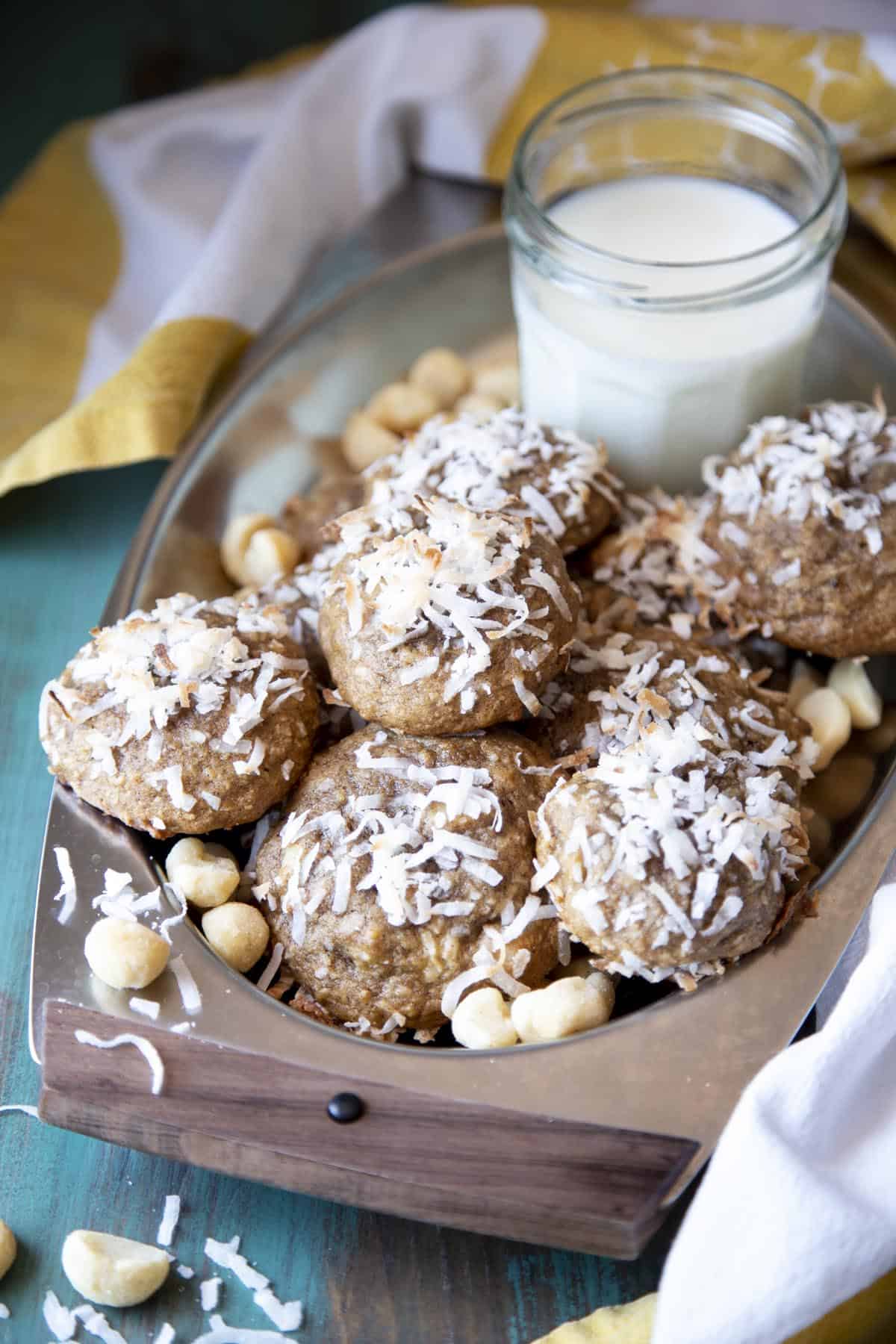 Banana cookies in a serving tray with a glass of milk.