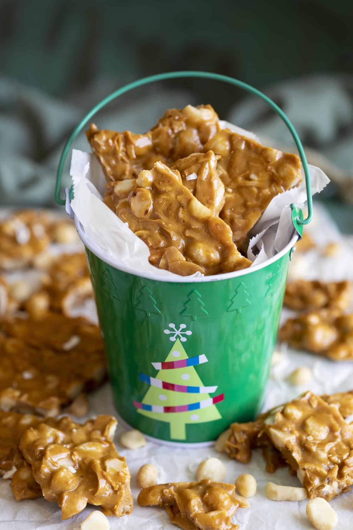 Brittle pieces in a green bucket surrounded by more brittle.