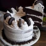 A slice of Oreo cake being lifted from the cake stand.