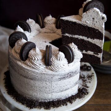 A slice of Oreo cake being lifted from the cake stand.