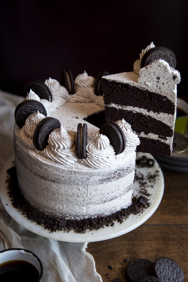 A slice of Oreo cake being lifted from the cake stand.
