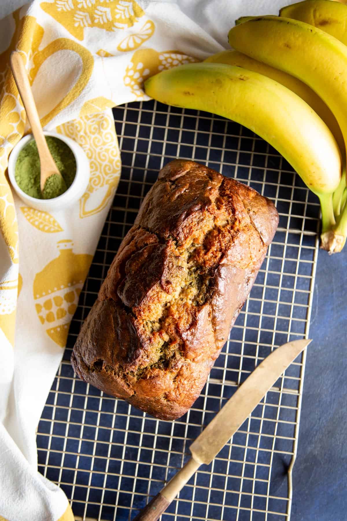 A loaf of matcha green tea banana bread on a wire rack.