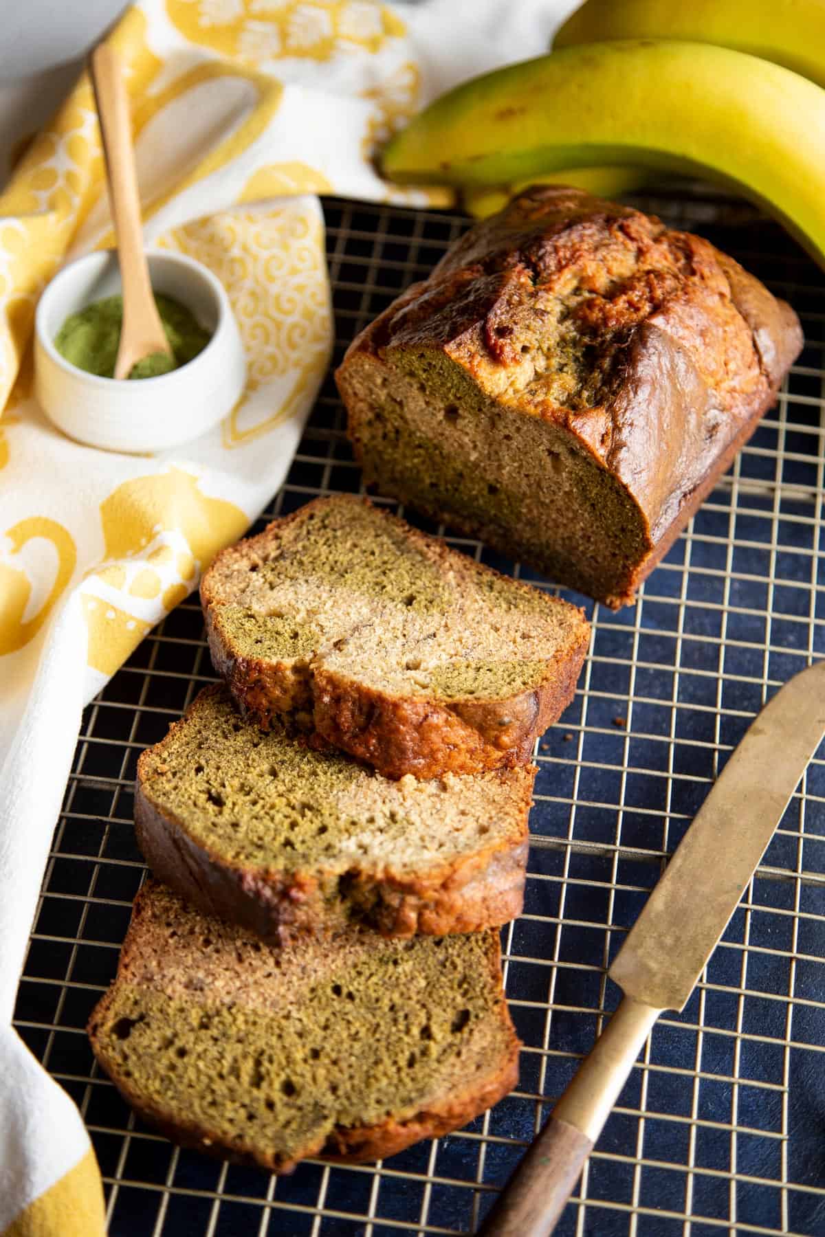Slices of matcha banana bread next to half a loaf.