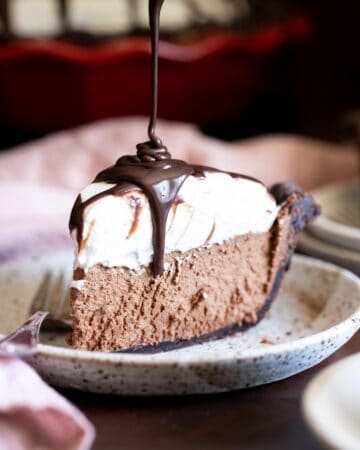 A slice of french silk pie with ganache drizzled on top.
