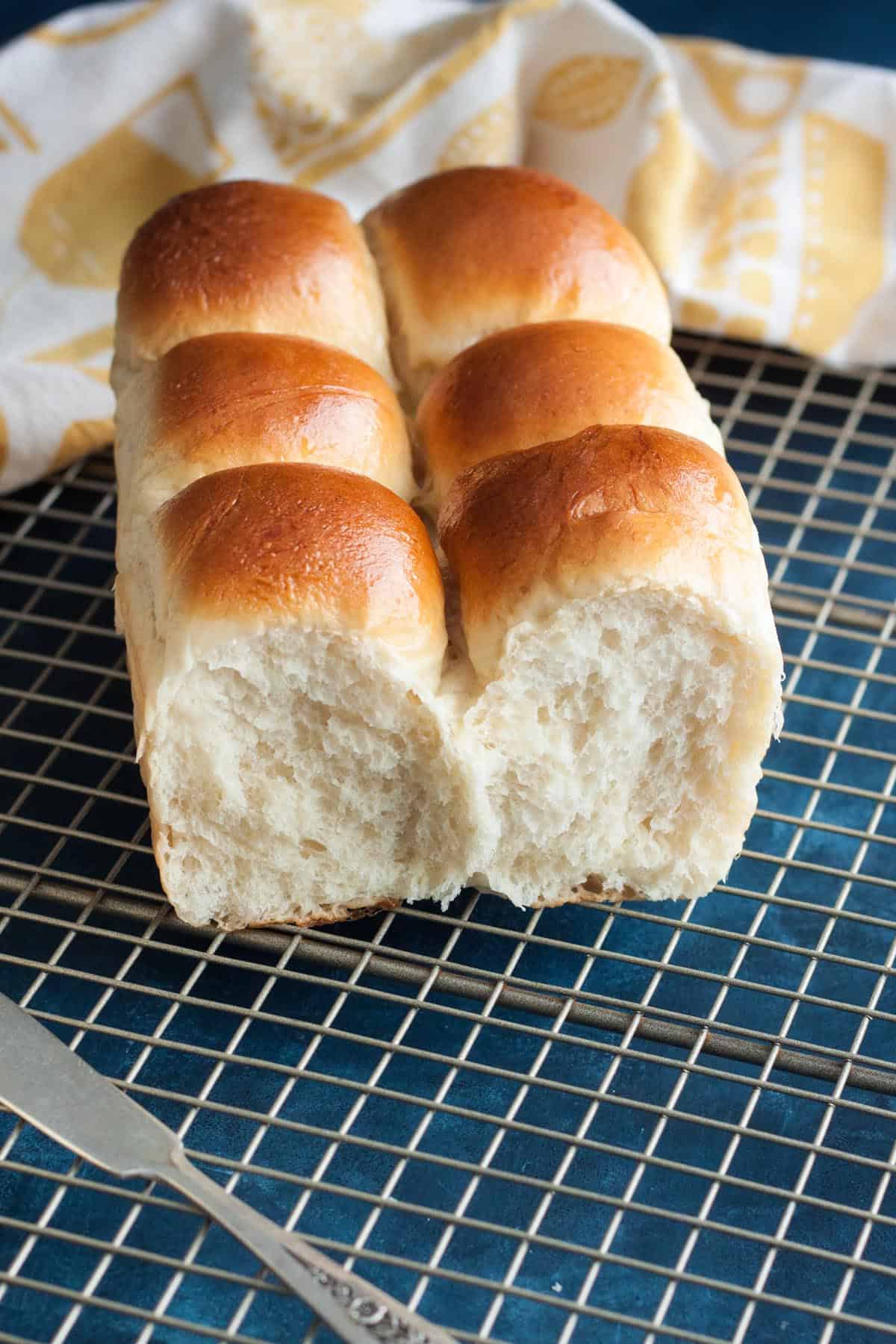 A loaf of milk bread with some sections already pulled apart.