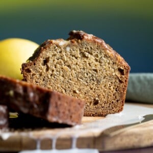 A loaf of lemon banana bread sliced open on a wooden board.