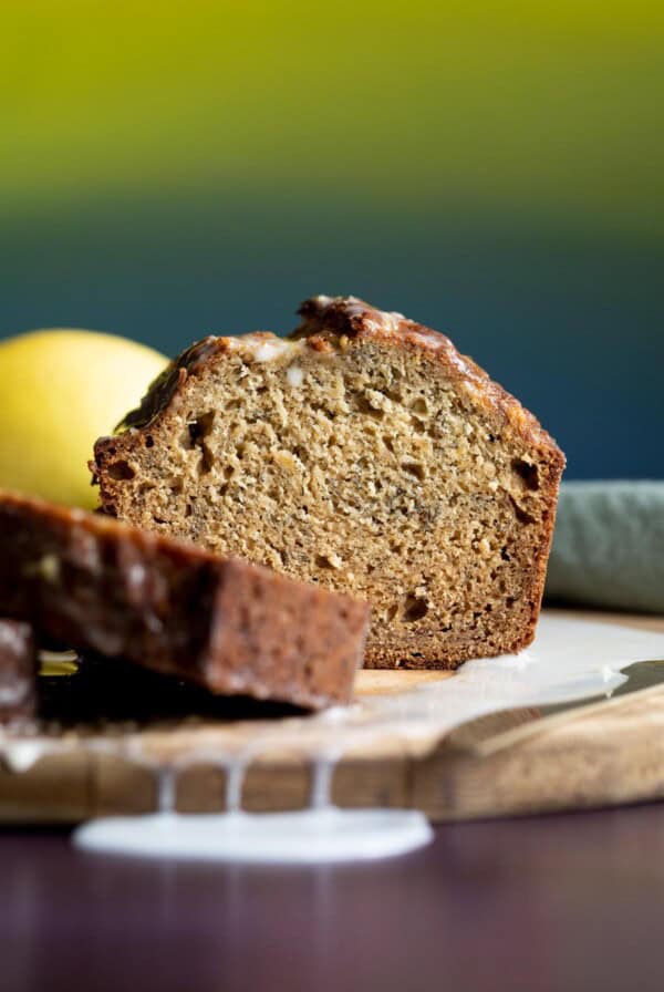 A loaf of lemon banana bread sliced open on a wooden board.