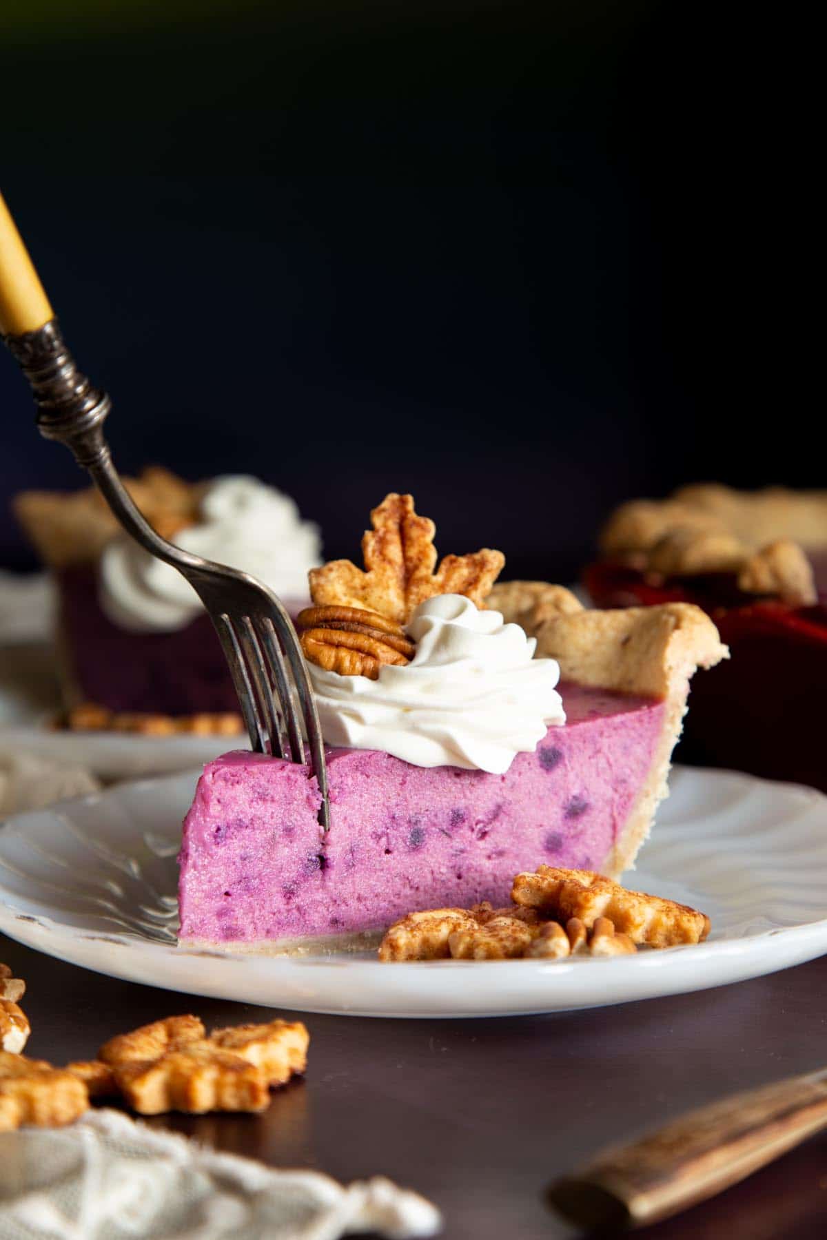 A fork is cutting into a slice of purple sweet potato pie.