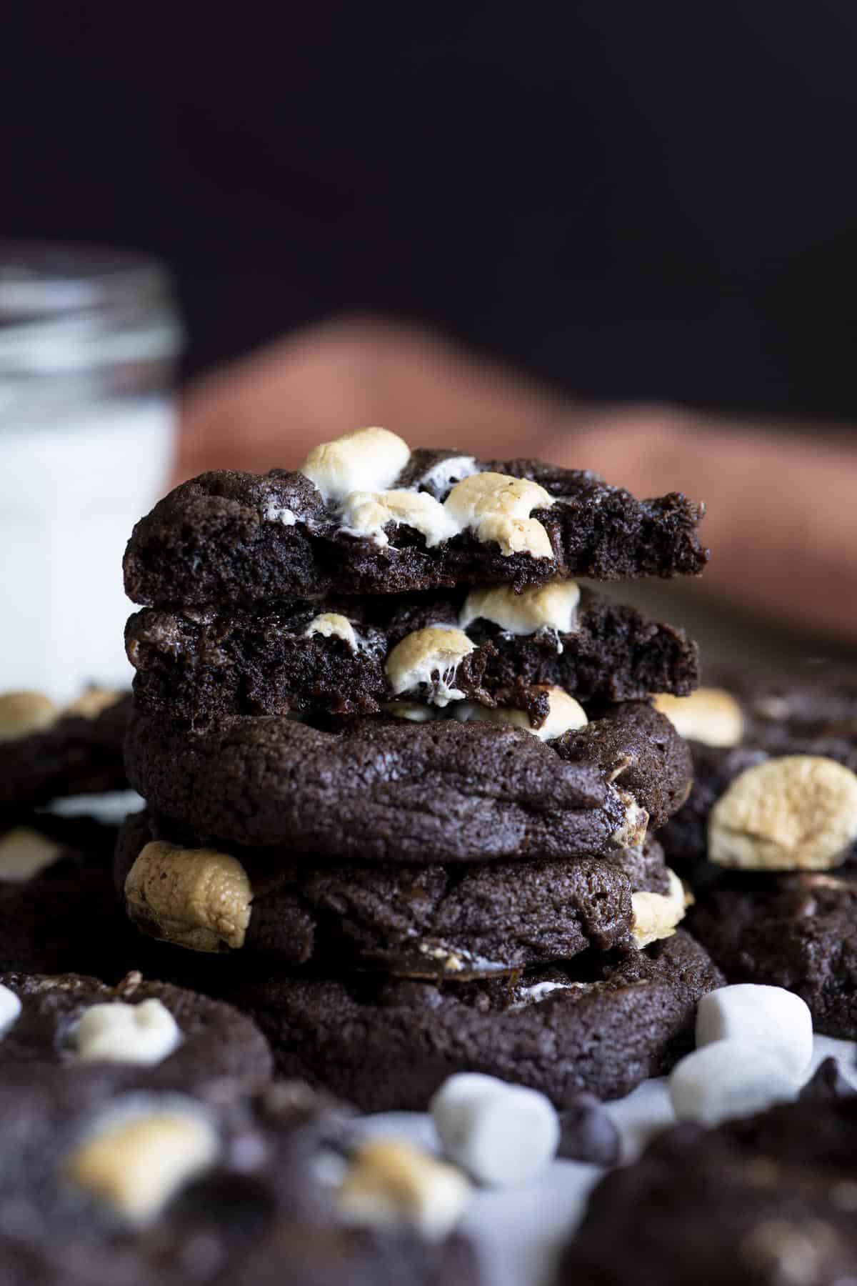 A stack of chocolate marshmallow cookies, the top cookies broken in half.