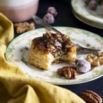 A half eaten mini pecan pie on a plate.