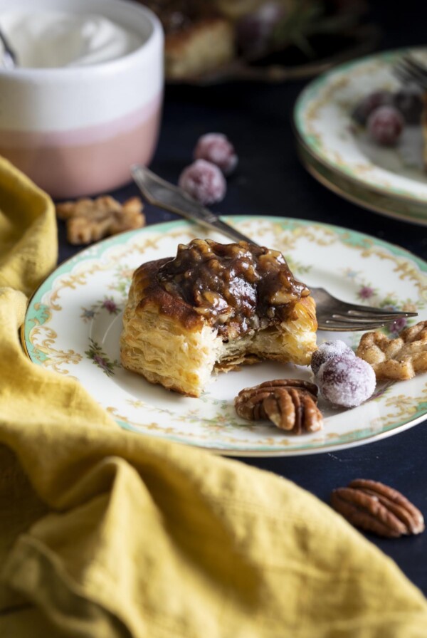 A half eaten mini pecan pie on a plate.