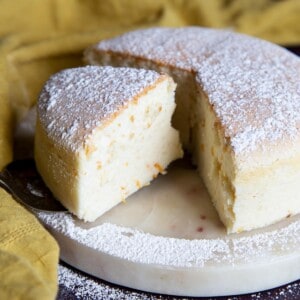 A fluffy Japanese cheesecake cut open on a marble plate.