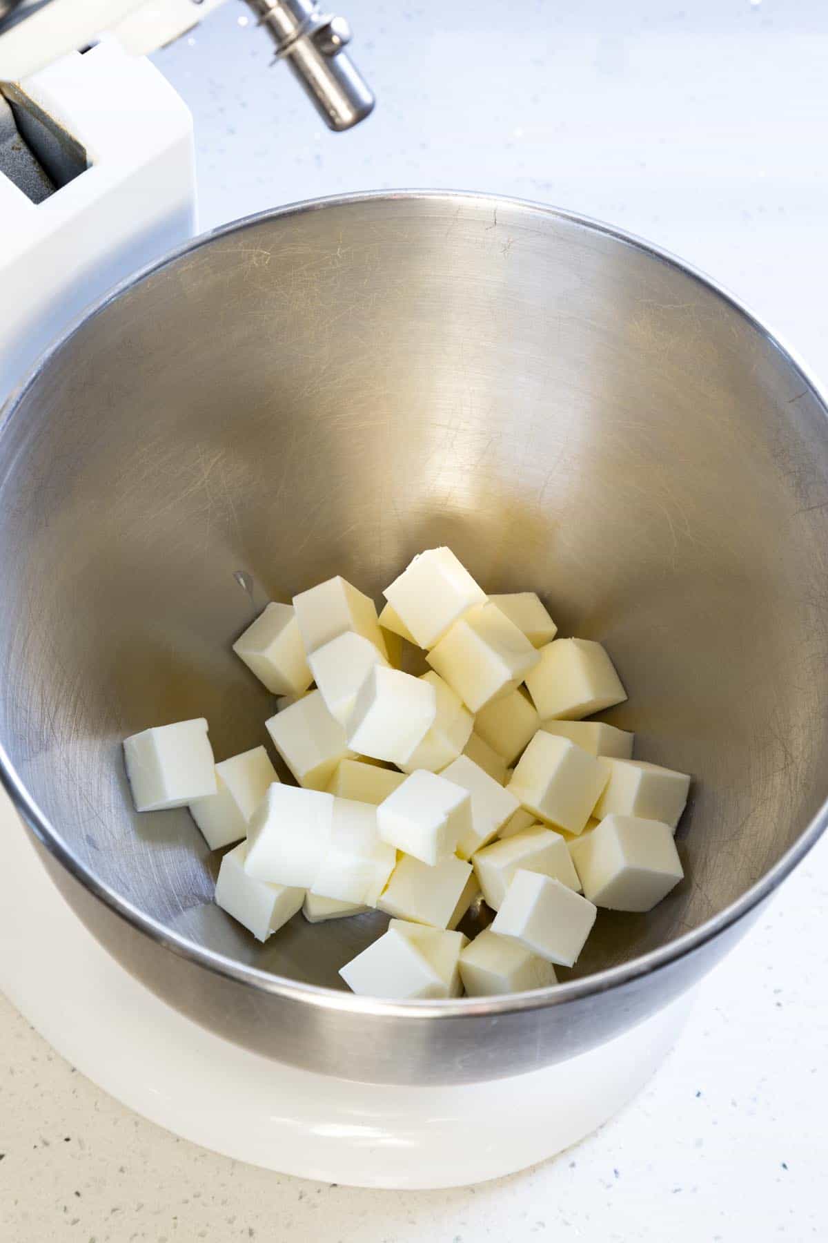 Adding butter to a stand mixer bowl.