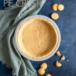 A vanilla wafer crust on a blue table top next to a green towel and vanilla wafer cookies all around.
