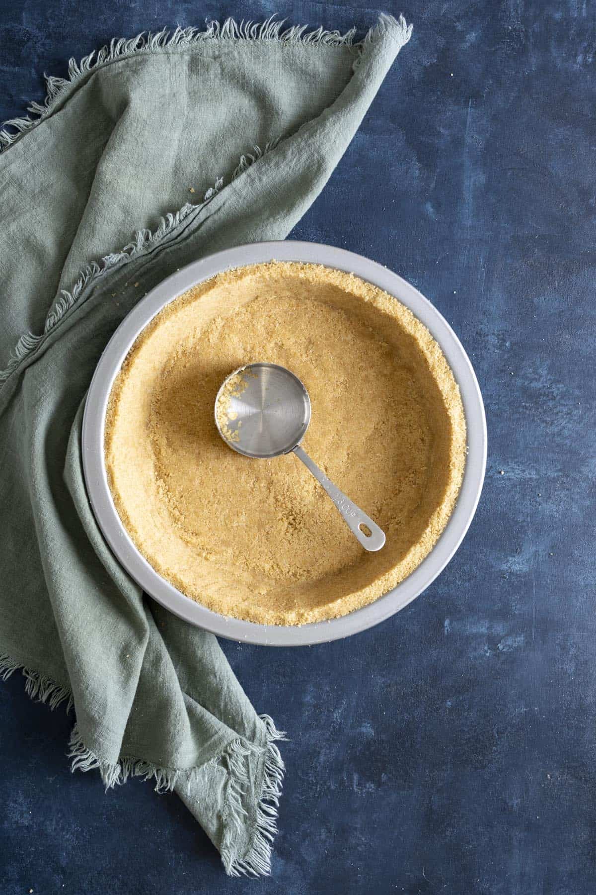 A vanilla wafer crust with a measuring cup inside the crust.