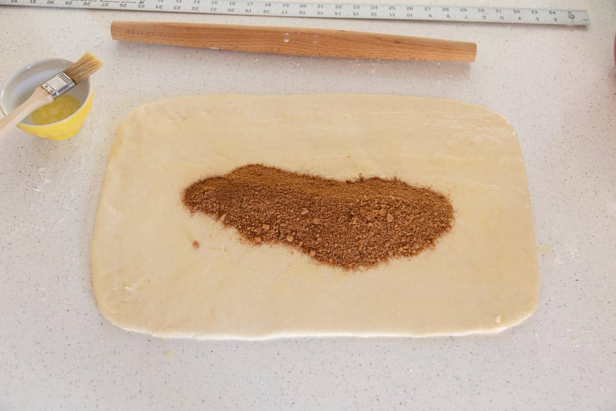 Cinnamon roll dough rolled out into a rectangle.