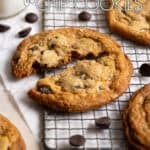 A toffee chocolate chip cookie, broken in half, sitting on top of a wire grating.