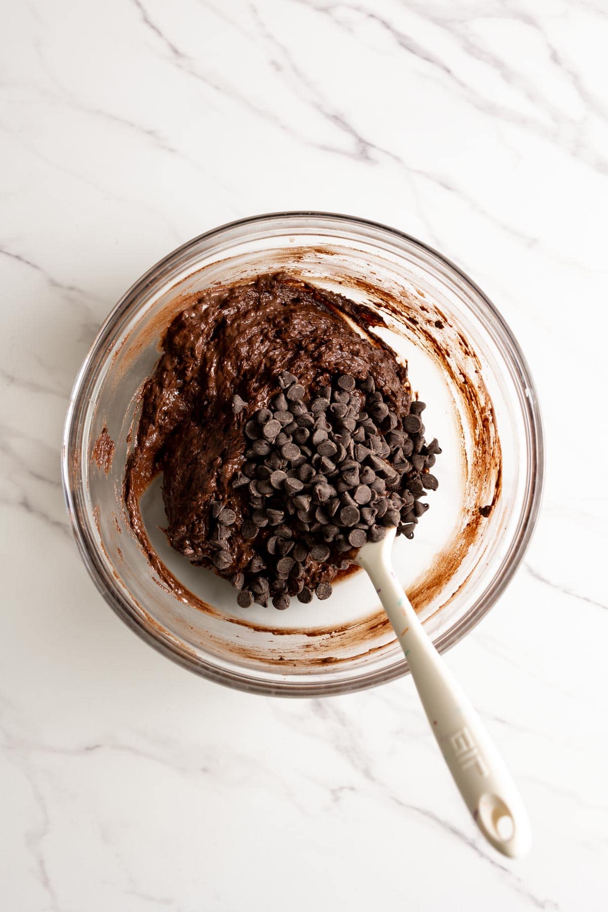 Adding chocolate chips to chocolate loaf cake batter.