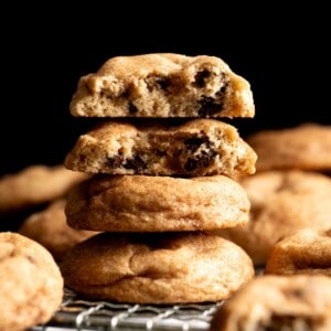 A stack of chocolate chip snickerdoodle cookies, the top two are broken in half showing the interior.
