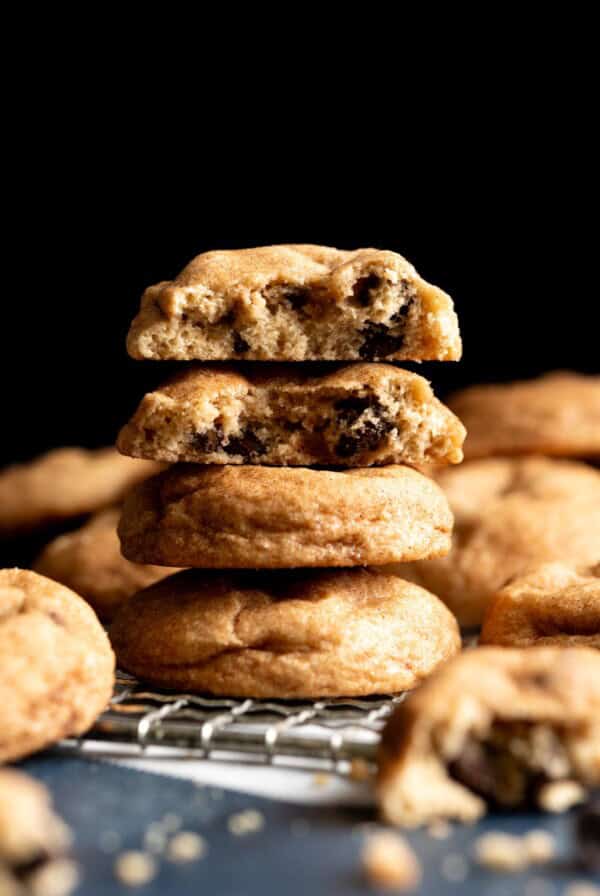 A stack of chocolate chip snickerdoodle cookies, the top two are broken in half showing the interior.