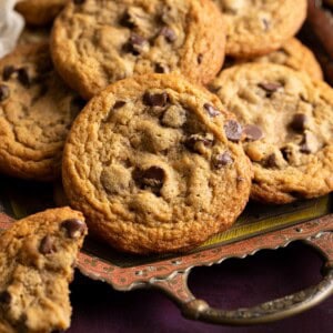 Miso chocolate chip cookies on a tray, half a cookie is resting on the side.
