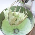 Mint buttercream frosting inside a stand mixer bowl.