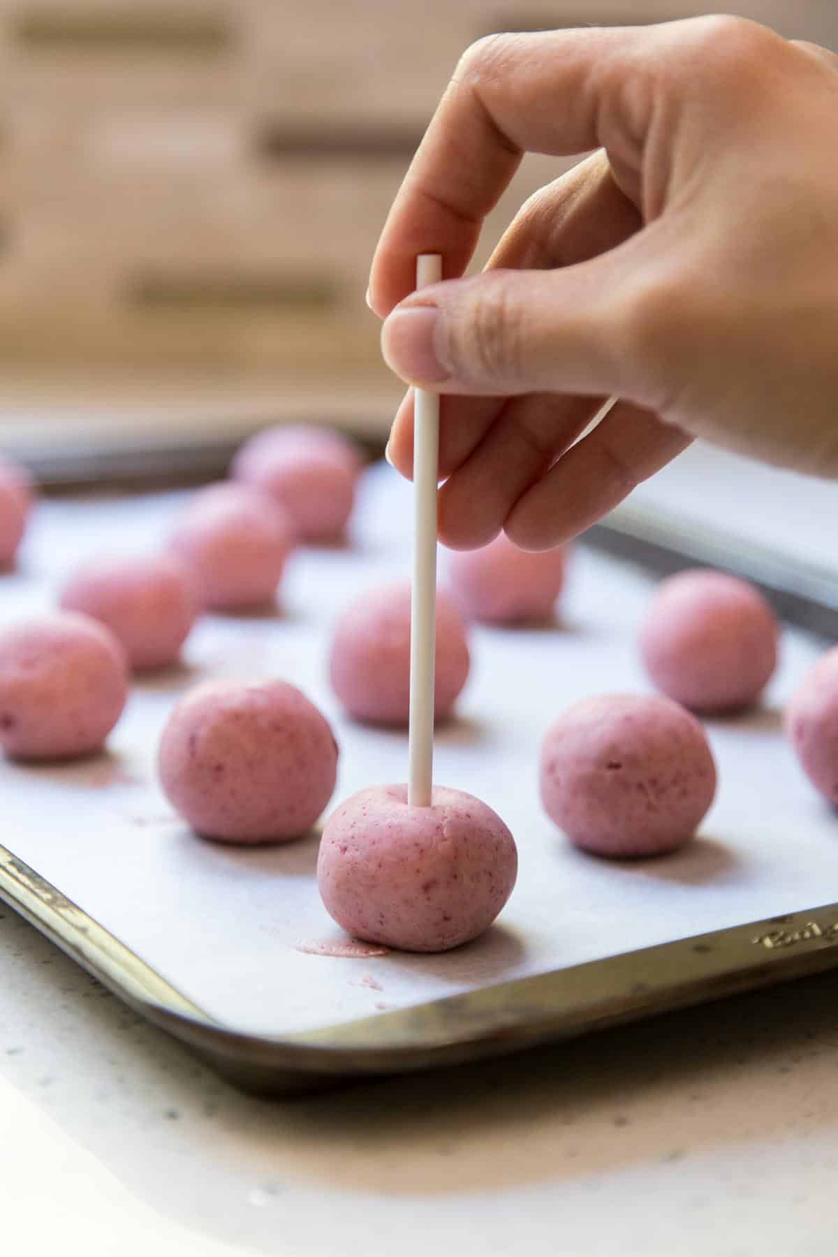 Add lollipop stick to a strawberry truffle.