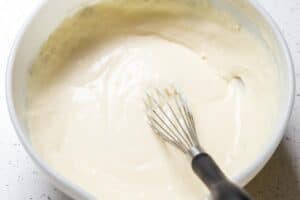 Wet ingredients mixed together in a mixing bowl for mango coconut cake.