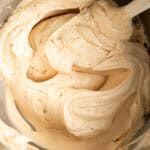 Creamy biscoff buttercream in a mixing bowl with a spatula.