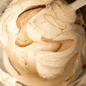 Creamy biscoff buttercream in a mixing bowl with a spatula.