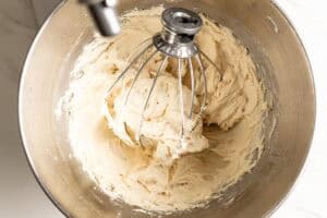 Fluffy brown butter cream cheese frosting in a stand mixer bowl.