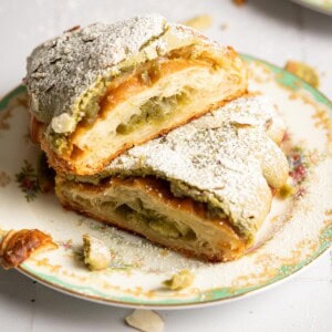 Two halves of a matcha croissant on a tea plate.