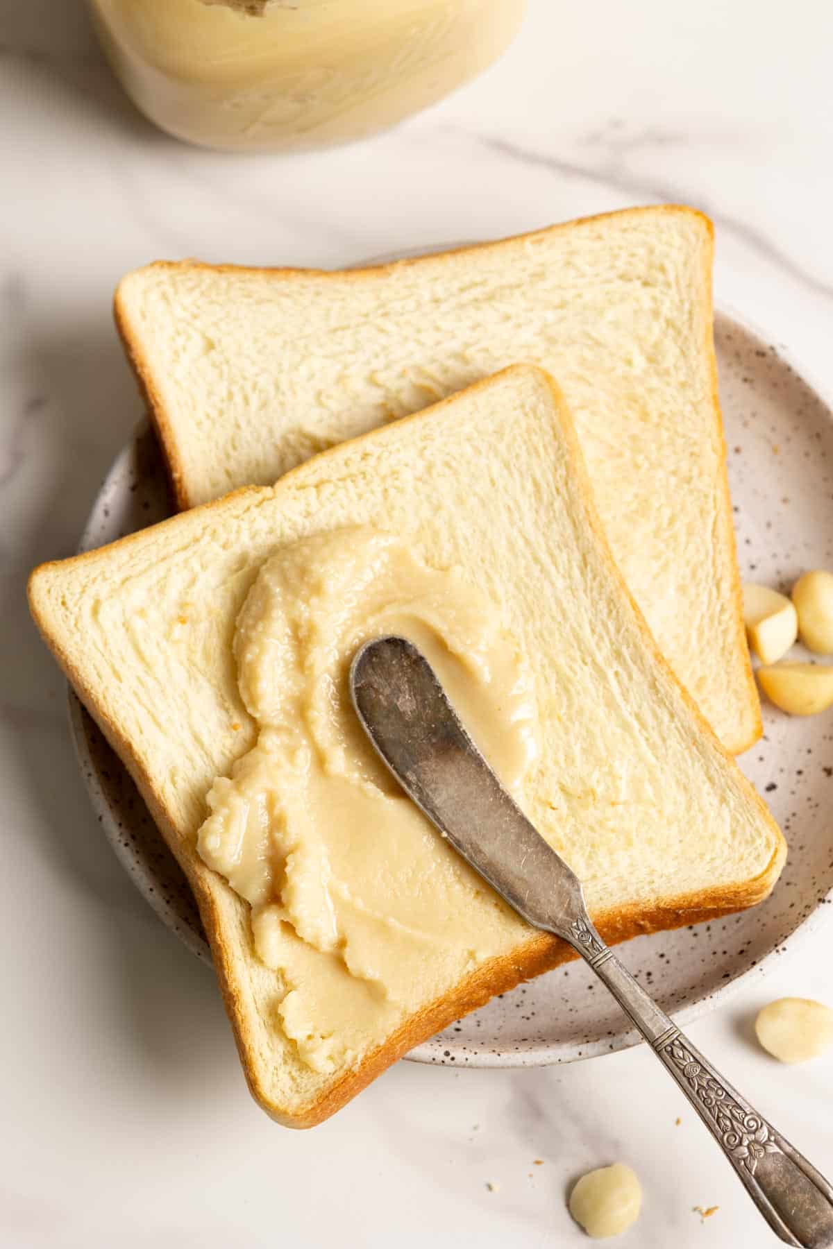 Spreading macadamia nut butter on toasts.