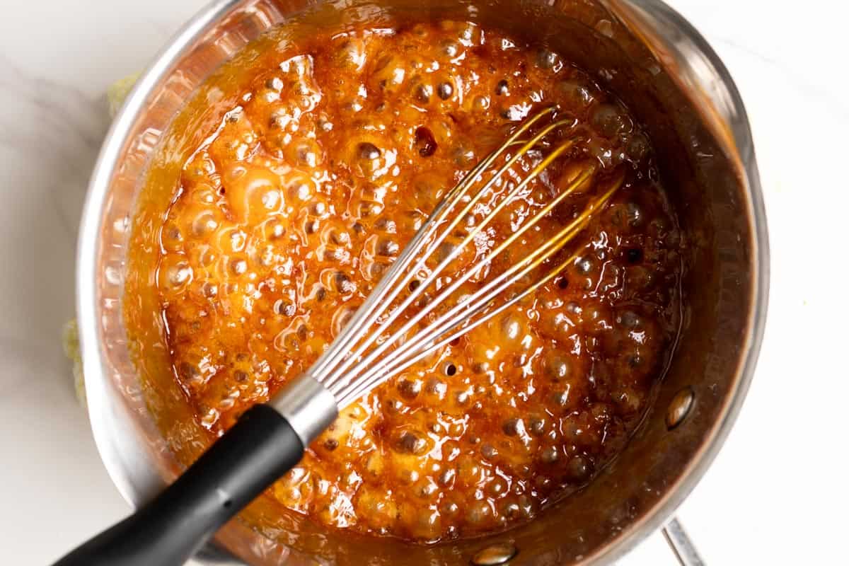 Caramel bubbles rapidly as butter is added.